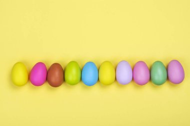 Satır parlak renkli Paskalya yumurta güneşli Sarı zemin üzerine