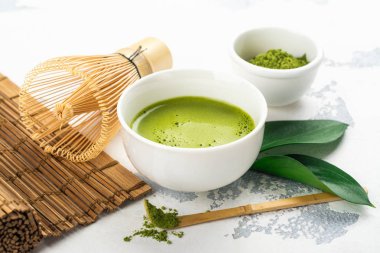 Beyaz zemin üzerine yeşil matcha çay içecek ve çay aksesuarları