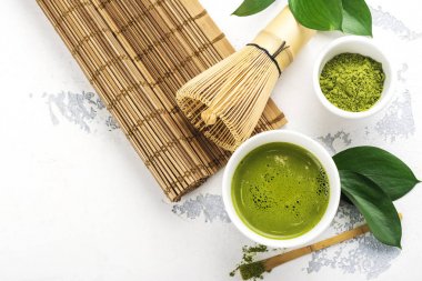 Beyaz zemin üzerine yeşil matcha çay içecek ve çay aksesuarları