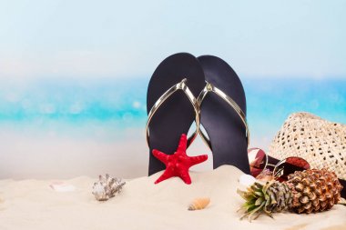Beach flip flop, şapka ve güneş gözlüğü Okyanusu yakınlarındaki güzel kumlu sahilde. Kopya alanı
