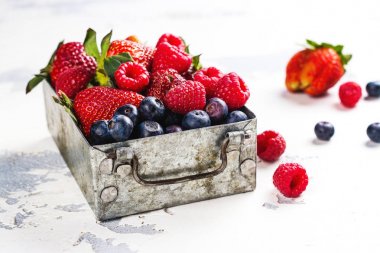 Taze çilek beyaz taş zemin üzerine metal bir kutu içinde karışımı