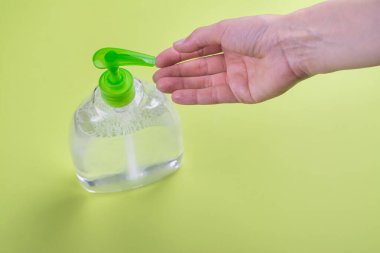 El dezenfektanı kullanıyor.