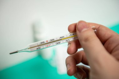 Koronavirüsün önlenmesi için dezenfekte spreyi veya antibakteriyel sabun ve yüz maskesi, üst görünüm, sıcaklık ve arka plan termometresi