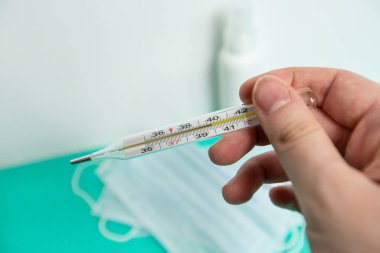 Koronavirüsün önlenmesi için dezenfekte spreyi veya antibakteriyel sabun ve yüz maskesi, üst görünüm, sıcaklık ve arka plan termometresi