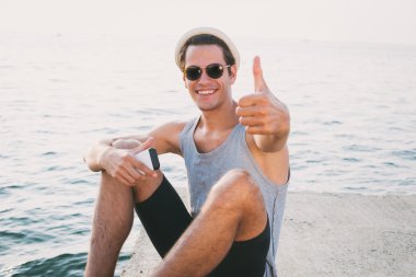 Genç hippi erkek gülümseyen ve gösterileri büyük parmak