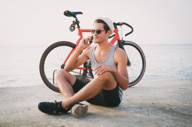 Denize yakın telefonda konuşurken onun sabit vites bisiklet adamla genç yenilikçi