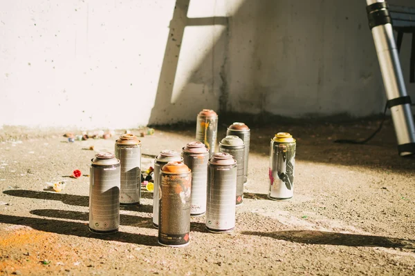 Aerosol spray bottles on the asphalt — Stock Photo, Image