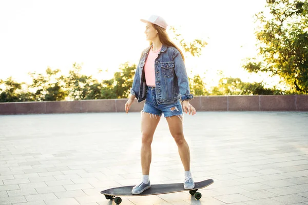 Menina montando longboard no beco ao nascer do sol ou pôr do sol — Fotografia de Stock