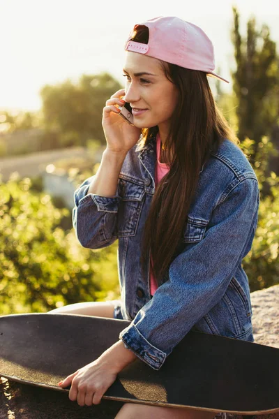 여자 longboard와 앉아서 전화 통화 — 스톡 사진