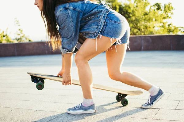 Young girl putting longboard on the pavement in park — Stock Photo, Image