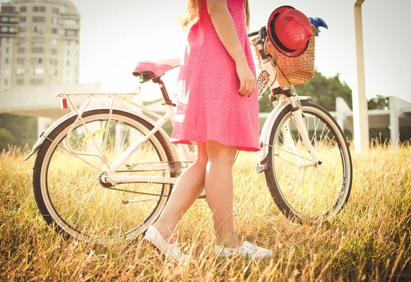 Jeune femme avec vélo de ville au lever ou au coucher du soleil — Photo