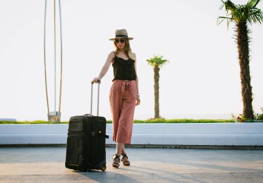 Seafront, bavul kalacak şapkalı şık kadın