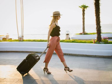 Seafront, bavul hallere şapkalı şık kadın