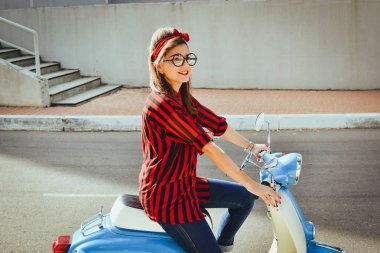 Mutlu genç hipster kadın vintage bir scooter şehirde sürüş gözlük