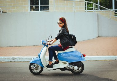 Mutlu genç hipster kadın vintage bir scooter şehirde sürüş gözlük