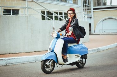 Mutlu genç hipster kadın vintage bir scooter şehirde sürüş gözlük