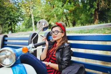 Bir tezgah ve Sigara İçilmeyen üzerinde oturan gözlüklü genç hipster kadın