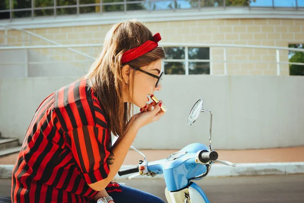 Jovem hipster mulher em óculos sentado em uma scooter vintage e pinta os lábios com batom vermelho — Fotografia de Stock