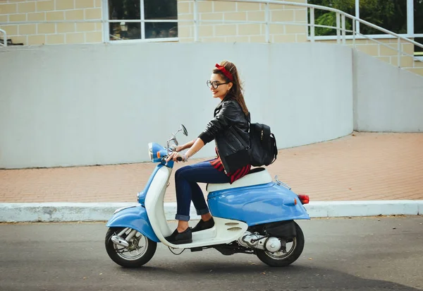 Mutlu genç hipster kadın vintage bir scooter şehirde sürüş gözlük