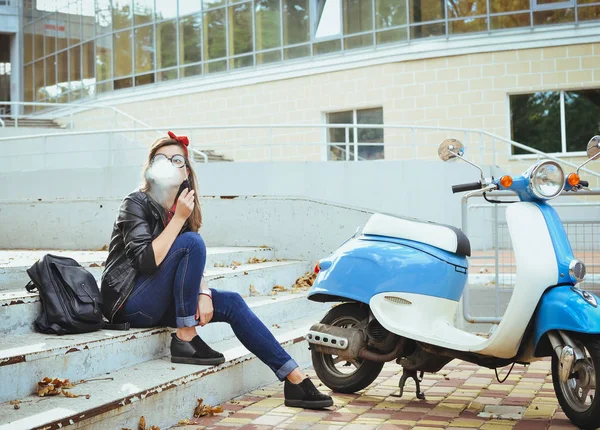 Jovem hipster mulher em óculos sentado nas escadas e fumar cigarro — Fotografia de Stock