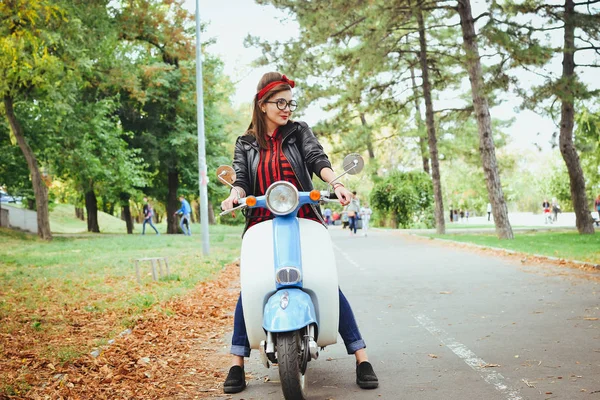Mutlu genç hipster kadın vintage bir scooter parkta sürüş gözlük — Stok fotoğraf