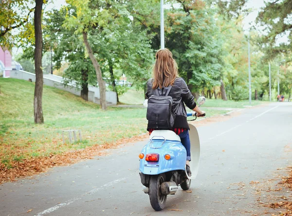 Young hipster woman driving a vintage scooter in park — Stock Photo, Image