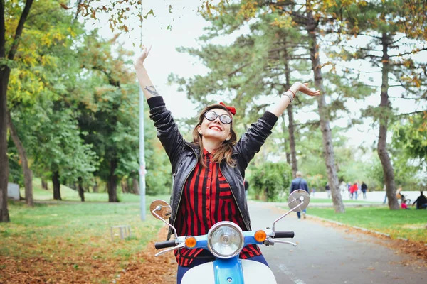 Mutlu genç hipster kadın parkta vintage scooter üzerinde eğleniyor gözlük — Stok fotoğraf