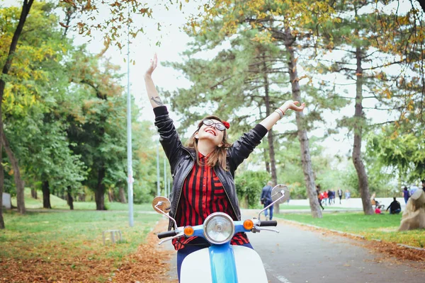 Mutlu genç hipster kadın parkta vintage scooter üzerinde eğleniyor gözlük — Stok fotoğraf
