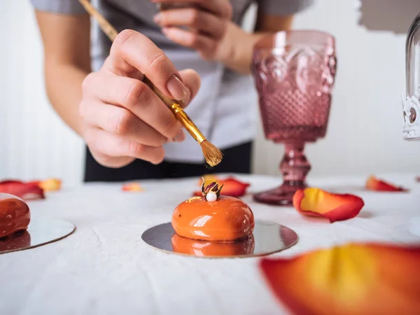 El confitero decorando con pincel el pastel en forma de corazón —  Fotos de Stock