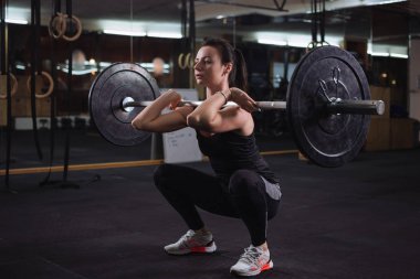 Genç ve güzel kadının yapması spor salonunda squats