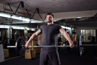 Spor salonunda ağırlık güçlü genç adam