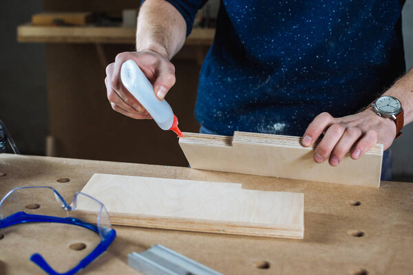 Young man using glue 