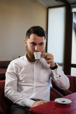 Kafede oturan ve kahve içme genç çekici adam