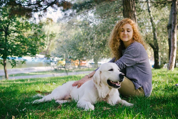 Genç kadın ile köpek parkta oturan