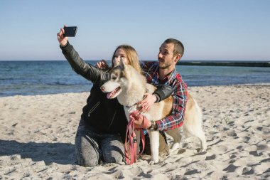 Sibirya husky köpek ile plajda Çift