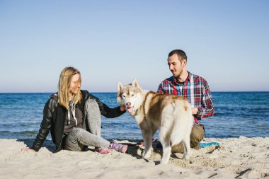 Sibirya husky köpek ile plajda Çift