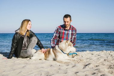 Sibirya husky köpek ile plajda Çift