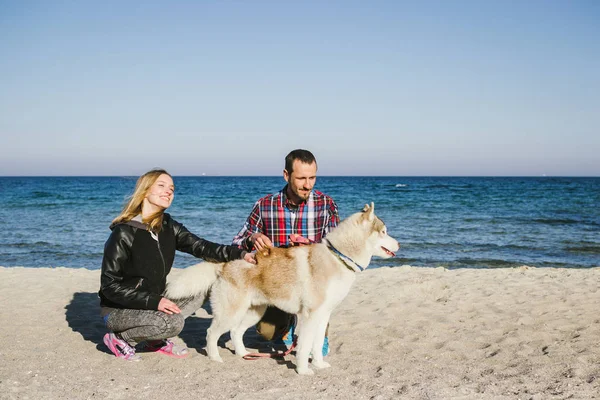 Paar am Strand mit sibirischem Husky-Hund — Stockfoto