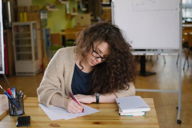 Ofiste çalışan ve bir şeyler yazıyor genç kadın 