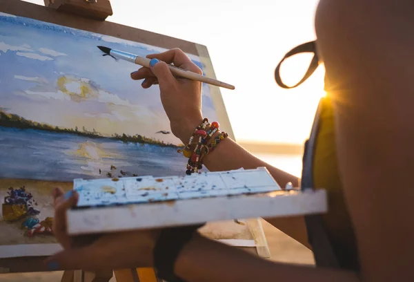 Jovem artista pintando paisagem ao ar livre na praia, close-up — Fotografia de Stock
