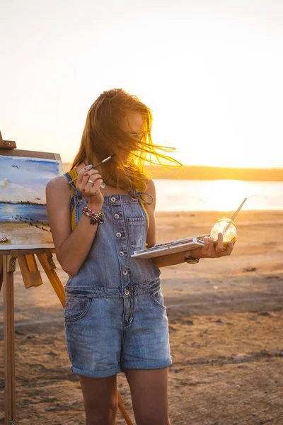 Joven artista pintando paisaje al aire libre en la playa —  Fotos de Stock