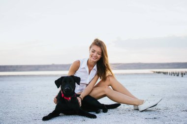 Genç erkek ile labrador retriever köpek sahilde günbatımı sarılma