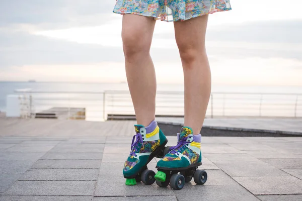 Jonge vrouw rolschaatsen in de buurt van de zee op roller squads, close-up — Stockfoto