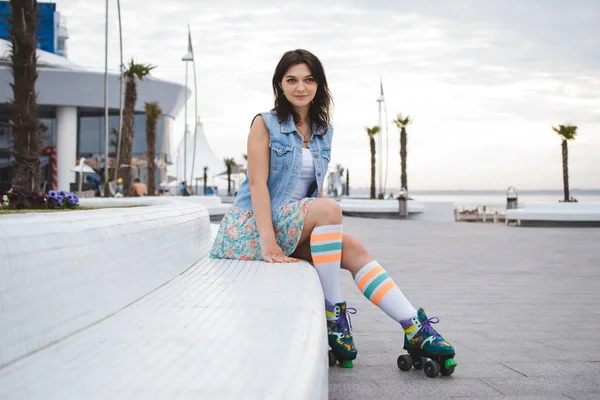 Retrato de mulher jovem patinando perto do mar em esquadrões de rolos — Fotografia de Stock