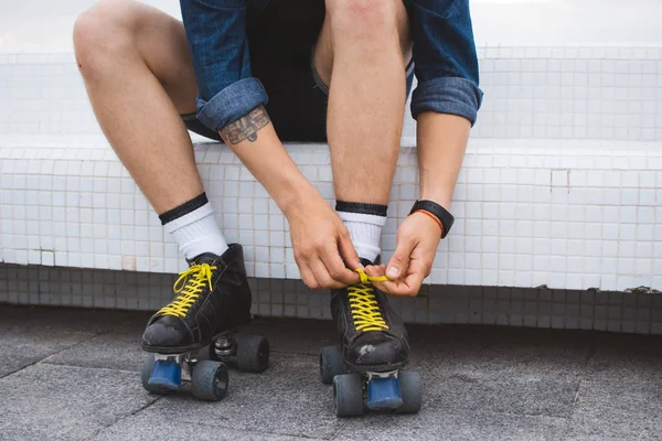 Joven hombre caucásico con patines quad rollos con herida en la pierna —  Fotos de Stock