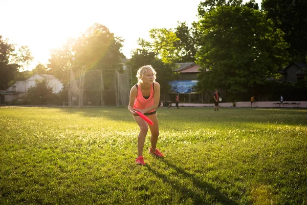 Jovem e bela mulher jogando frisbee no parque — Fotografia de Stock