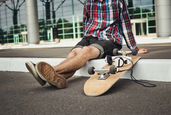 Primer plano del hombre con monopatín y auriculares en la calle —  Fotos de Stock