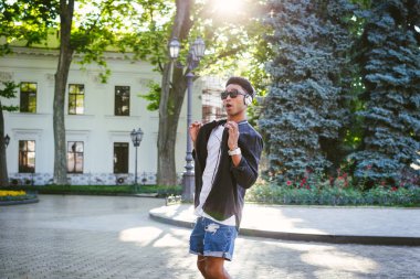 Şaka yapıyordum genç şık hipster siyah adam beyaz kulaklık ve şehir merkezinde açık dans güneş gözlüğü portresi