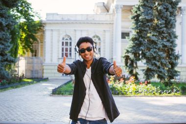 Şaka yapıyordum genç şık hipster siyah adam beyaz kulaklık ve şehir merkezinde açık dans güneş gözlüğü portresi
