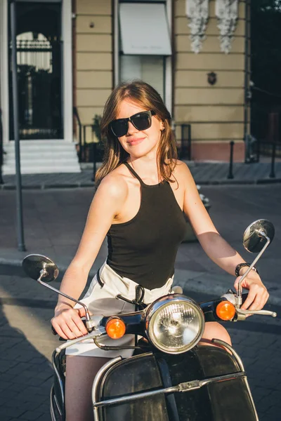 Женщина в городе с ретро скутером — стоковое фото
